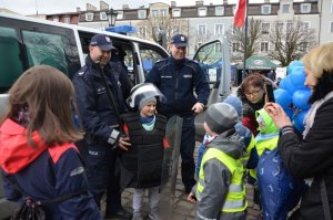 Policjanci pokazują dzieciom strój używany w trakcie zabezpieczeń np. meczy piłkarskich