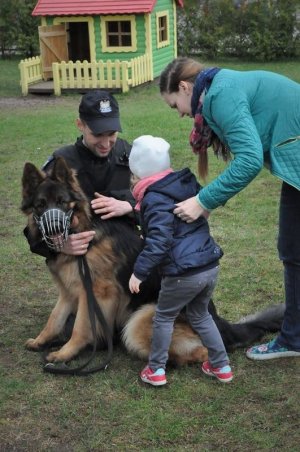 Policjant pokazuje dziecku psa służbowego