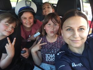 Policjantka z dziećmi w radiowozie
