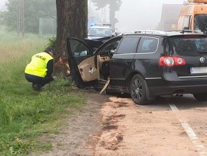Policjant przy rozbitym samochodzie