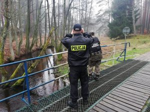 policjanci i straż rybacka w lesie