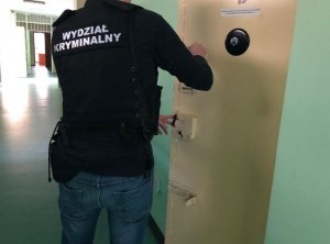 Policjant zamyka drzwi celi