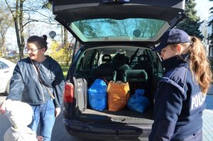 Policjantka przekazuje worki z nakrętkami mamie Nikodema