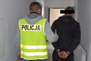 Policjant prowadzi zatrzymanego