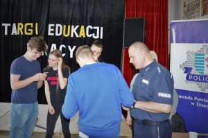 Policjant rozmawia z uczniami na temat pracy policjanta