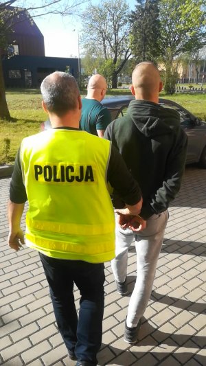 Policjanci prowadzą zatrzymanego