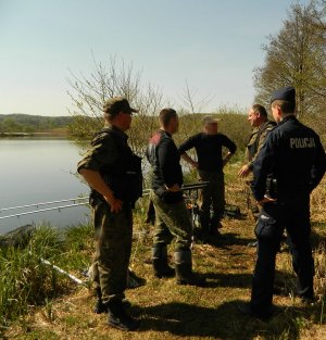policjant ze strażą rybacką w środowisku leśnym