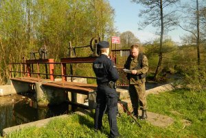 policjant ze strażą rybacką w środowisku leśnym