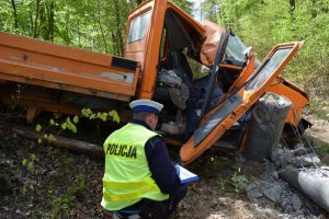 policjant wykonuje oględziny na miejscu wypadku