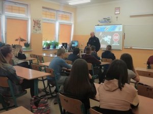 policjant mówi do uczniów w klasie