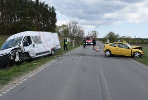 Policjanci pracują na miejscu wypadku, w tle uszkodzone samochody