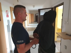 Policjant prowadzi zatrzymanego