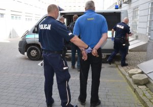 Policjant prowadzi zatrzymanego