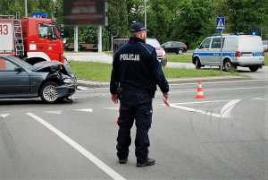 Policjant na miejscu wypadku, stoi na skrzyżowaniu