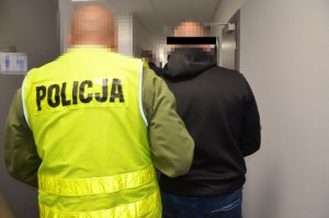 Policjant prowadzi zatrzymanego