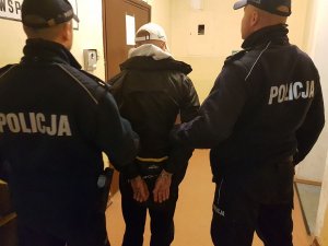 Policjanci prowadzą zatrzymanego