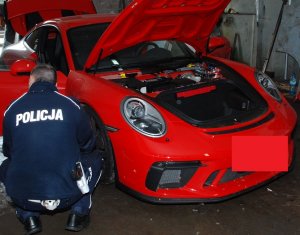 Policjant przy odzyskanym porsche