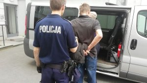 Policjant prowadzi zatrzymanego