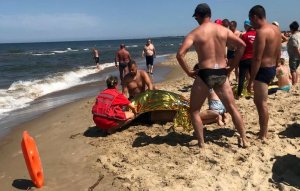 policjant na plaży udziela pomocy