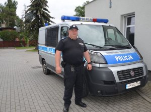 Policjant stoi przy radiowozie