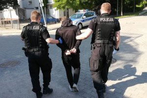 Policjanci prowadzą zatrzymanego