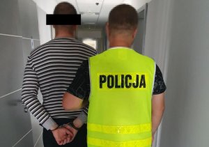 Policjant prowadzi zatrzymanego