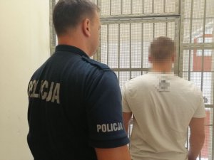 Policjant prowadzi zatrzymanego