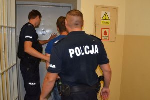 Policjanci prowadzą zatrzymanego