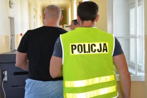 Policjant prowadzi zatrzymanego