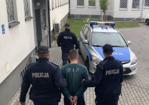 Policjanci prowadzą zatrzymanego