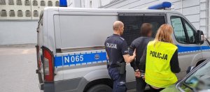 Policjanci prowadzą zatrzymanego.