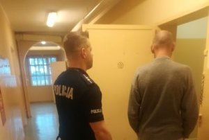 Policjant prowadzi zatrzymanego