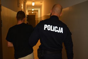 Policjant prowadzi zatrzymanego