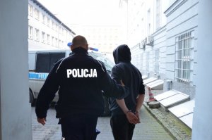 Policjanci prowadzą zatrzymanego