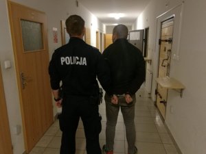 Policjant prowadzi zatrzymanego