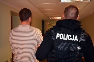 Policjant prowadzi zatrzymanego