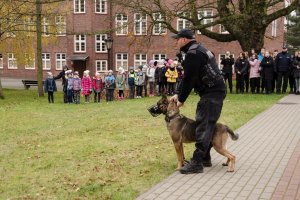 Policjant podczas prezentacji psa służbowego