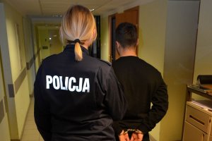 Policjantka prowadzi zatrzymanego