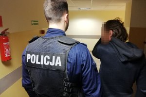 Policjant prowadzi zatrzymanego