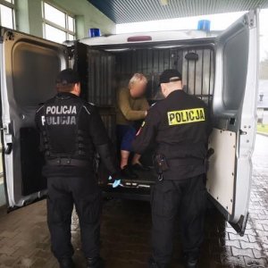 Policjanci transportują zatrzymanego