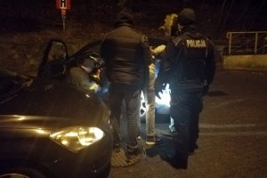 Policjanci prowadzą zatrzymanego