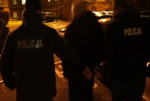 Policjanci prowadzą zatrzymanego