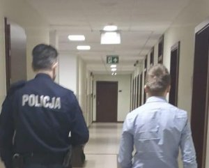 Policjant prowadzi zatrzymanego