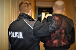 Policjant prowadzi zatrzymanego