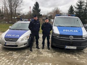 Policjanci stoją przy radiowozie