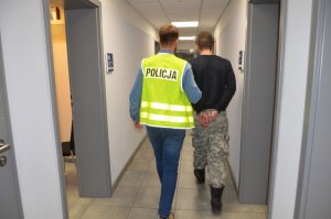 Policjant prowadzi zatrzymanego