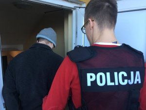 policjant prowadzi zatrzymanego