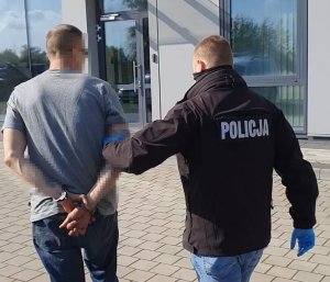 Policjant prowadzi zatrzymanego