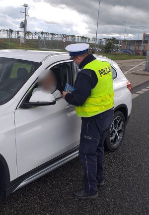 Policjant kontroluje kierującego samochdem