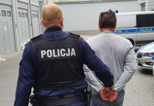 Policjant prowadzi zatrzymanego